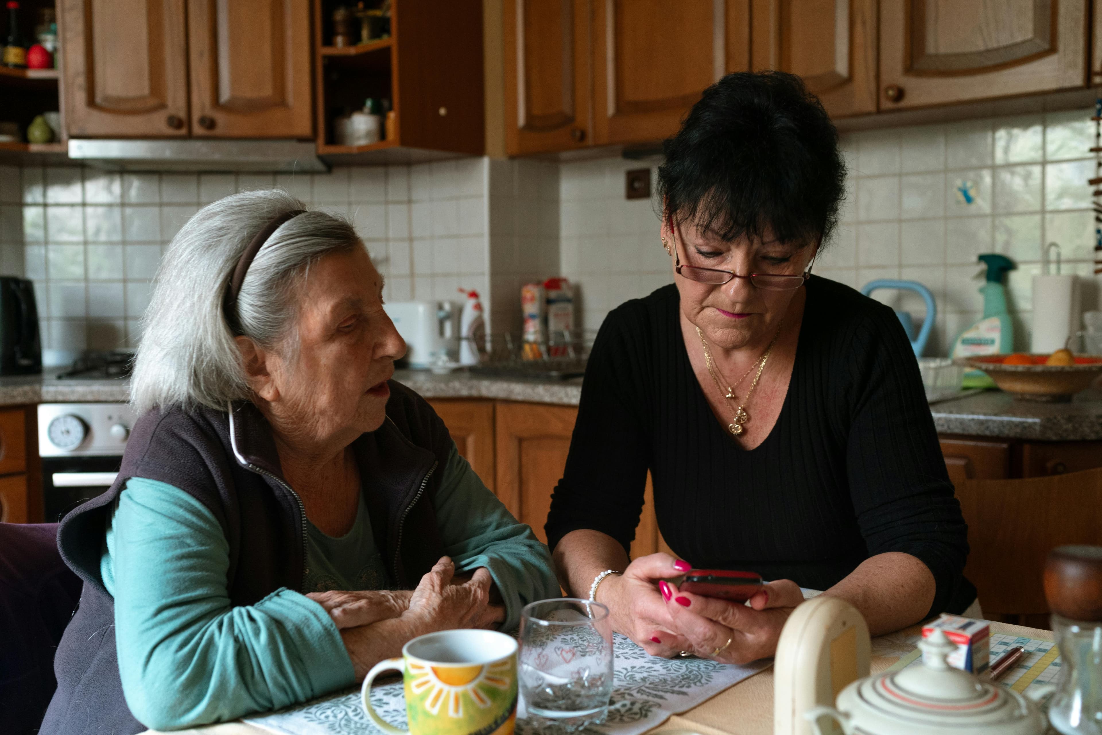 A caregiver and older adult sharing a supportive conversation at home