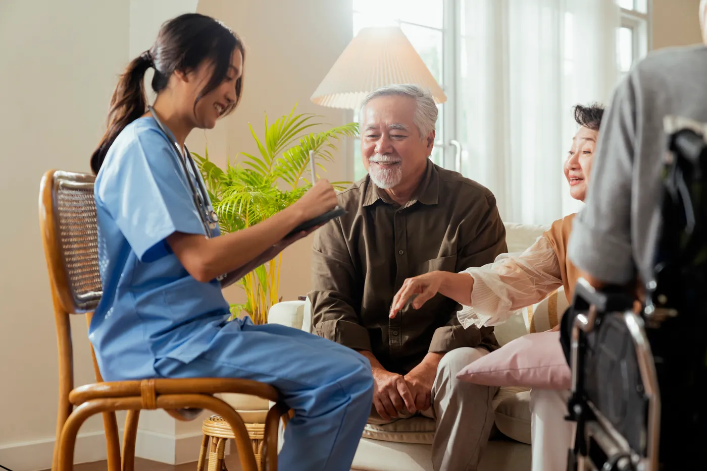 A care worker talking with an older man and woman at home
