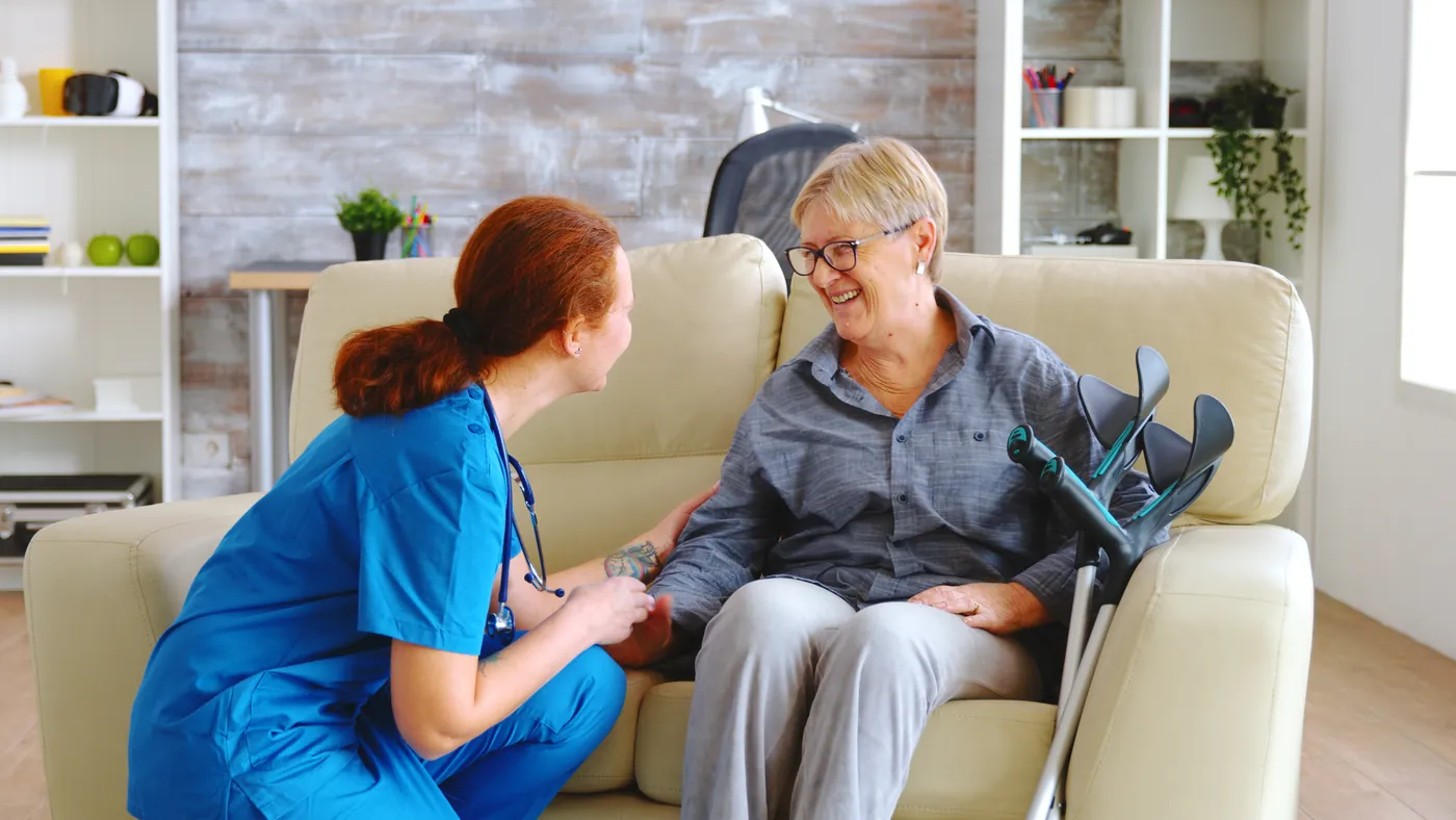 A female care worker speaking with an older woman at home